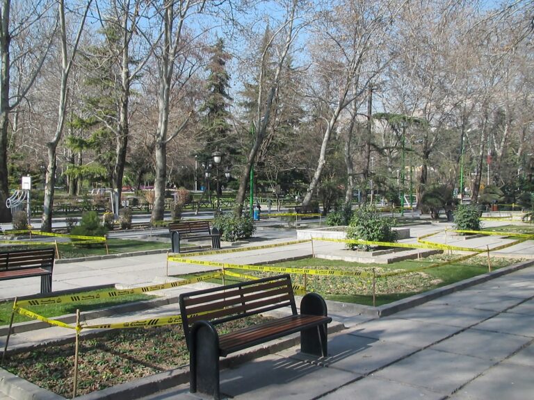 a park with benches and yellow caution tape